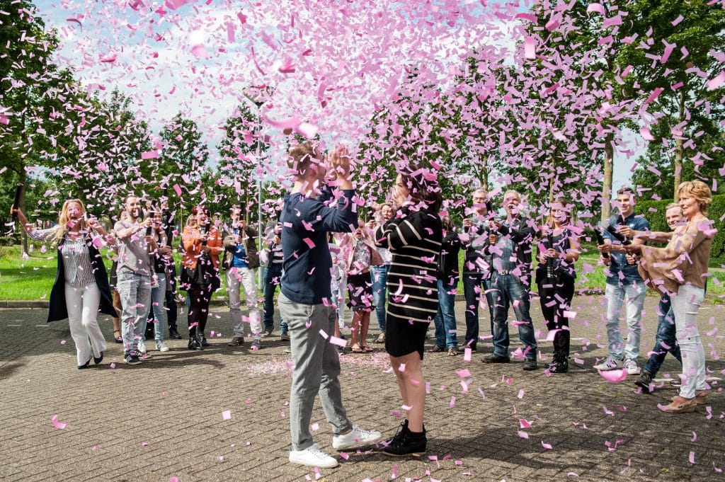 A joyful gender reveal party with pink and blue smoke